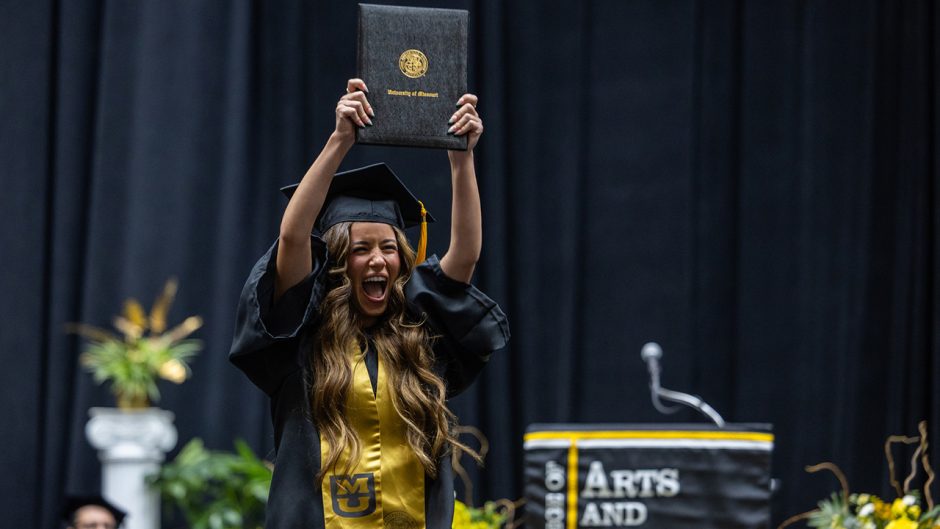 Graduate holds degree above head