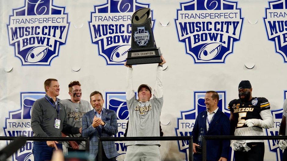 Man holds trophy over head