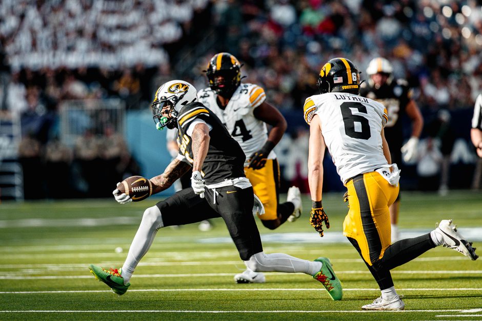 Football players run on field