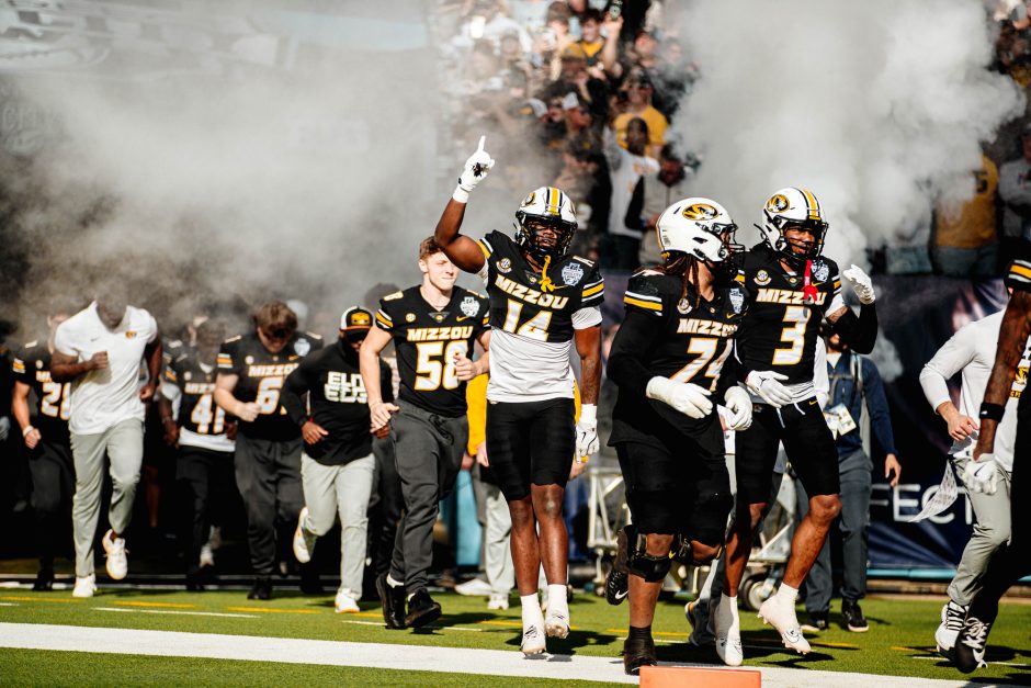 Football players on field with smoke in background