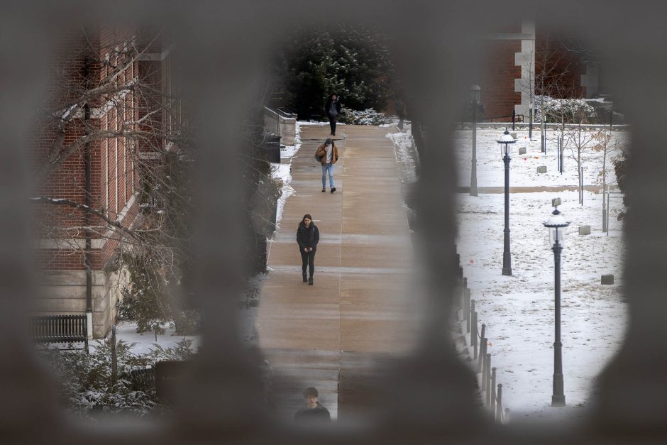 View through architecture showing person walking and snow-covered campus