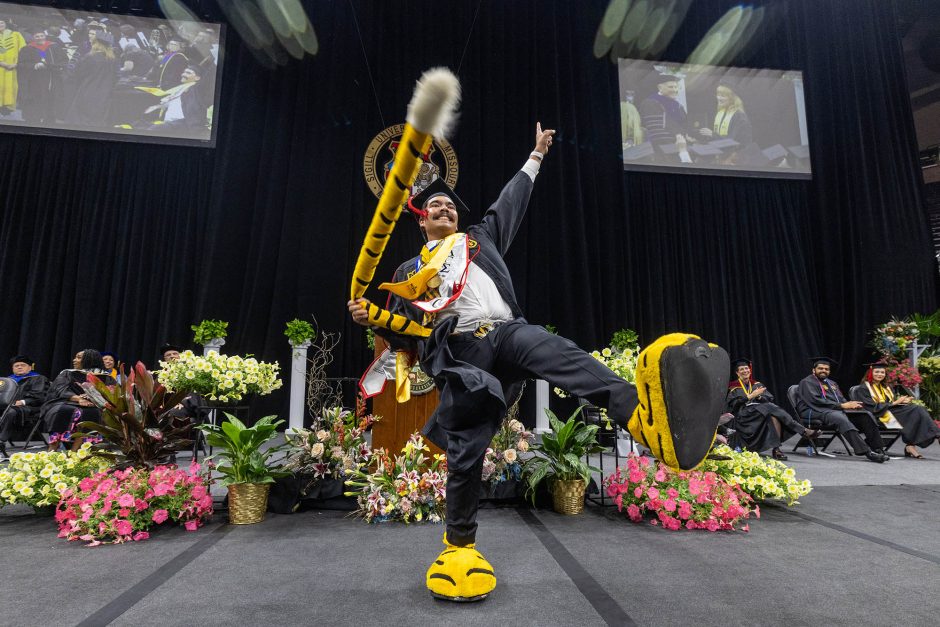 Graduate reveals Truman mascot tail and feet under gown