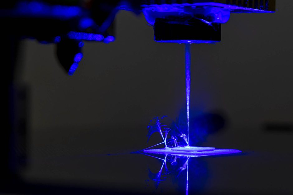 Purple light illuminates laser of 3D printer