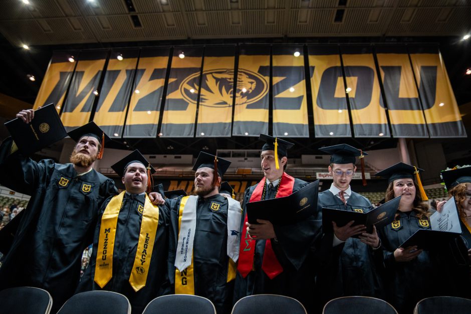 Graduates stand in front of Mizzou sign