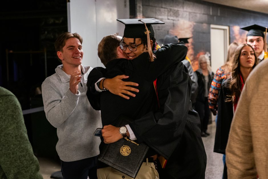 Graduate hugs friend