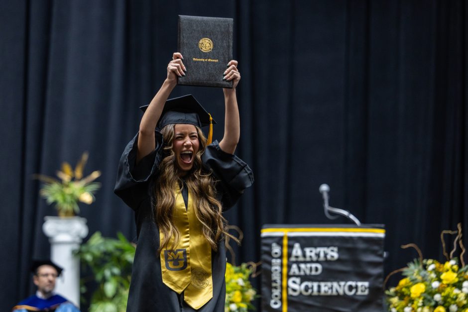 Graduate holds degree above head