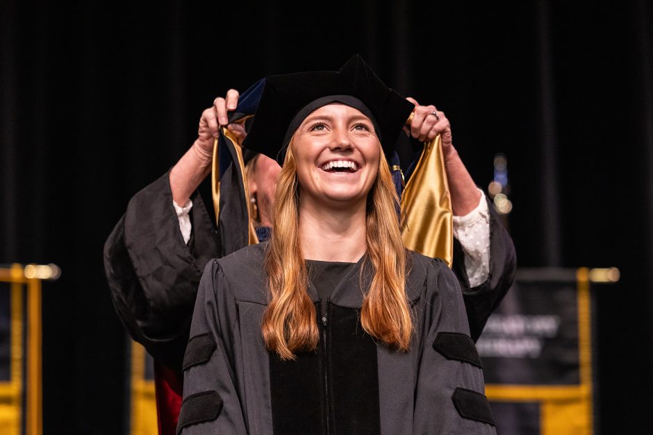 Graduate smiles as she's being hooded