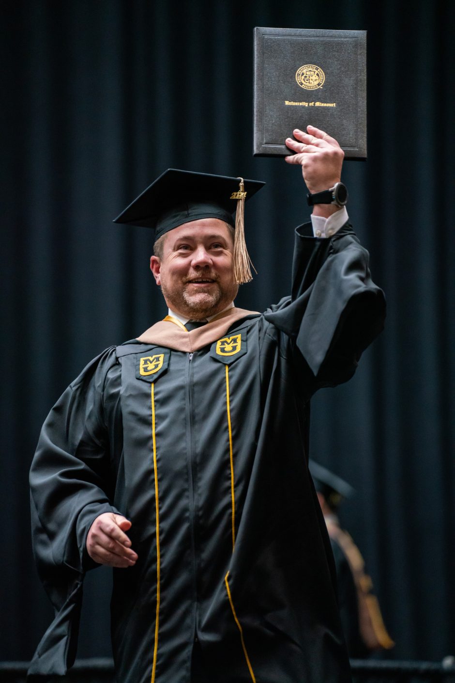 Graduate holds up degree