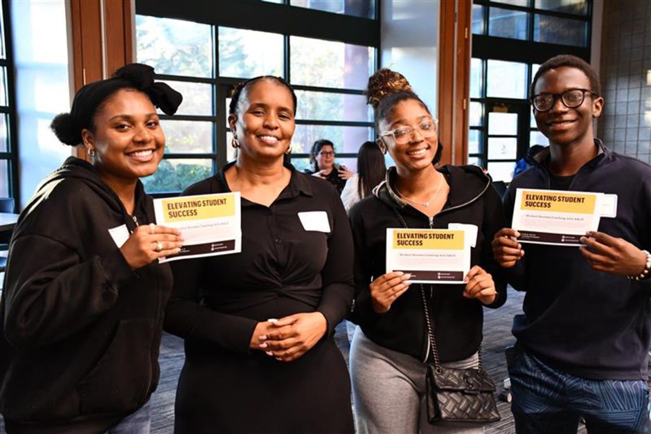 Three students hold student success certificates while posing with Velma Buckner