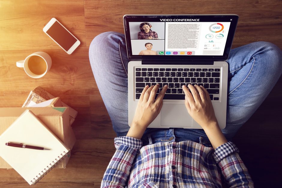 Person on floor with laptop surrounded by coffee, notebook and phone