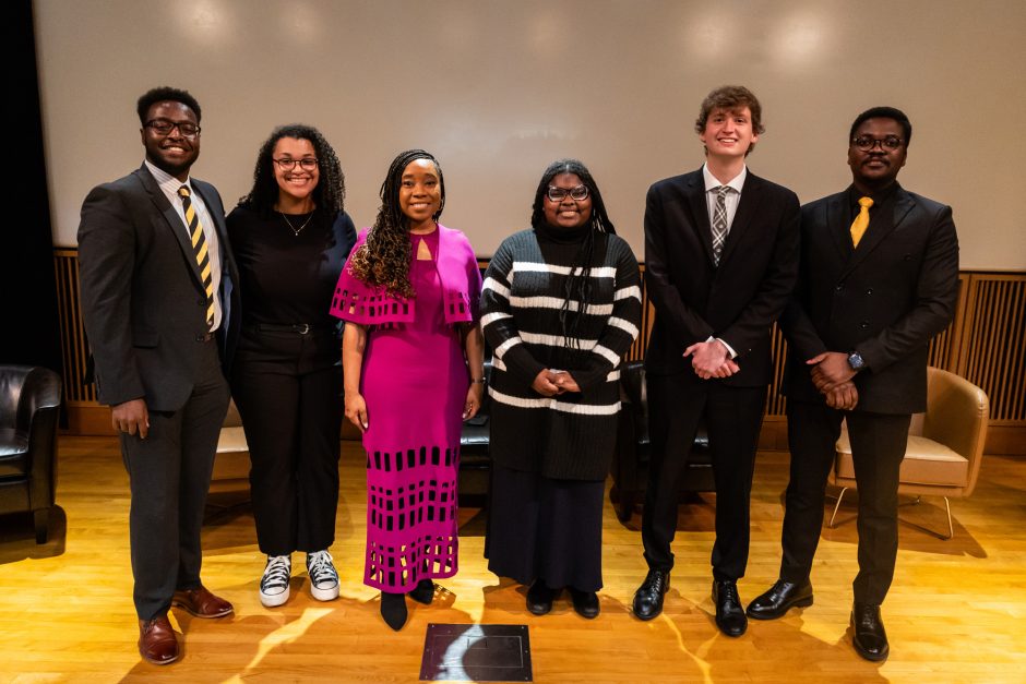 Group of people on stage pose for camera