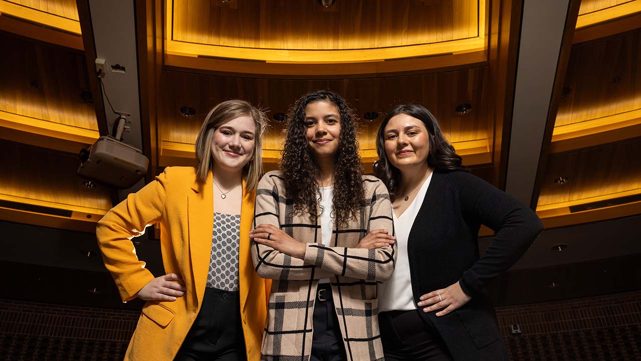 Erika LeFauve, Danielle Dodd and Mariana Larson pose in the court room at Mizzou Law School.