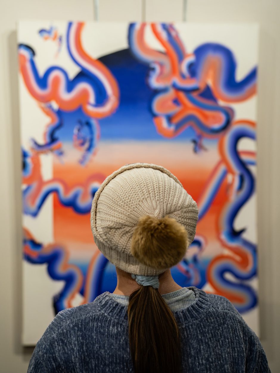 Woman looks at blue and orange artwork