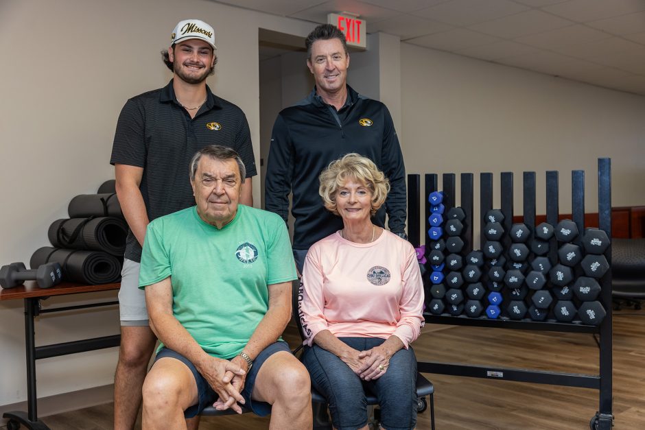 The Ball family poses in front of weights and dumbbells 