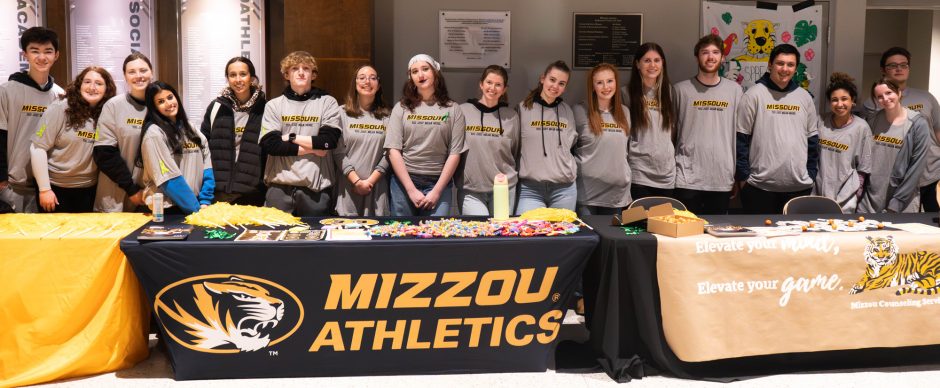 Large group of students in front of display table