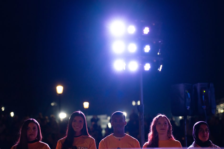 Students smiling under stadium lights