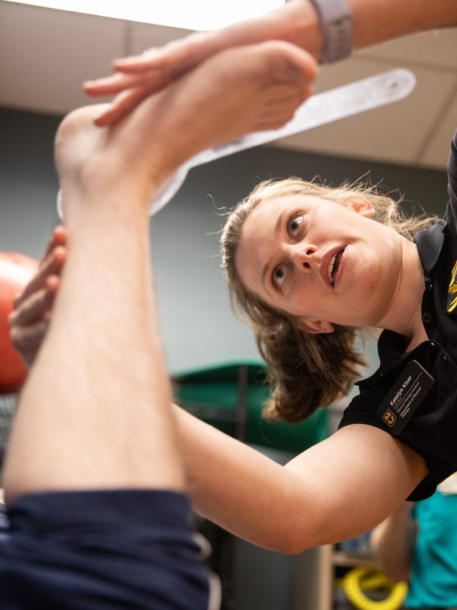 Health sciences student assists with physical therapy