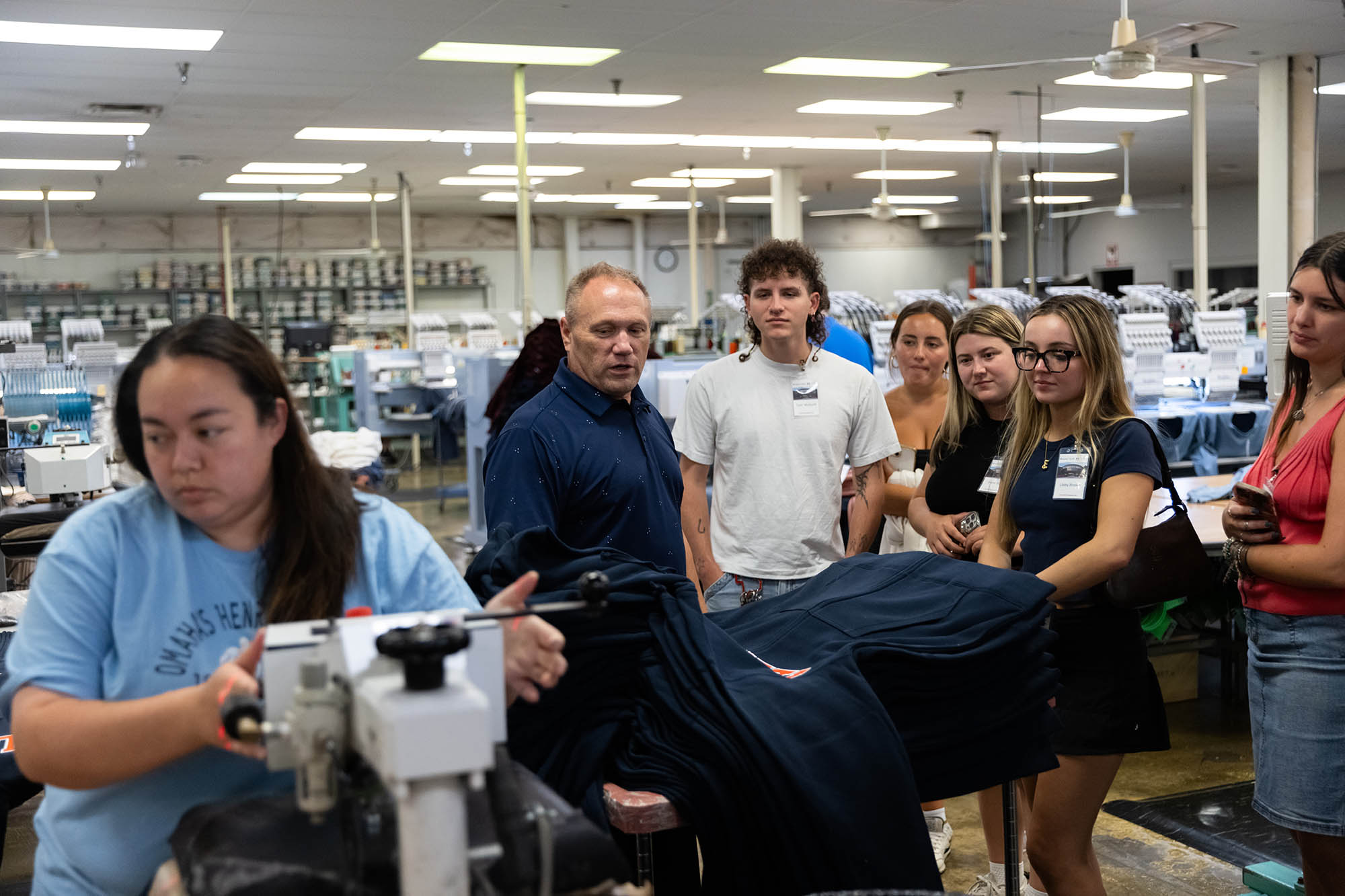 Man talking with students about embroidery and patches.