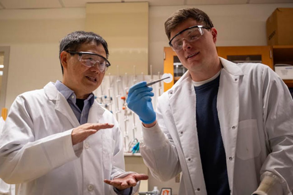 Two people in lab coats and goggles