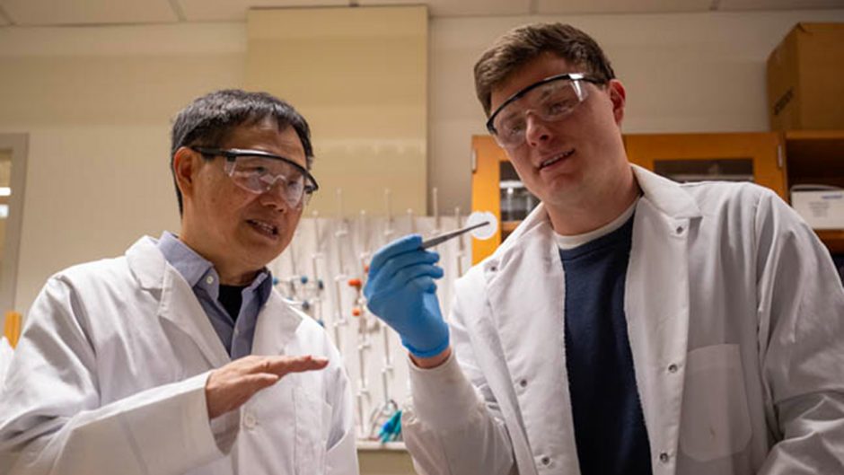 Two people in lab coats and goggles