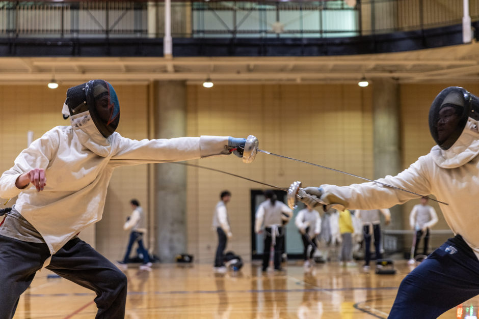 two people engaged in fencing