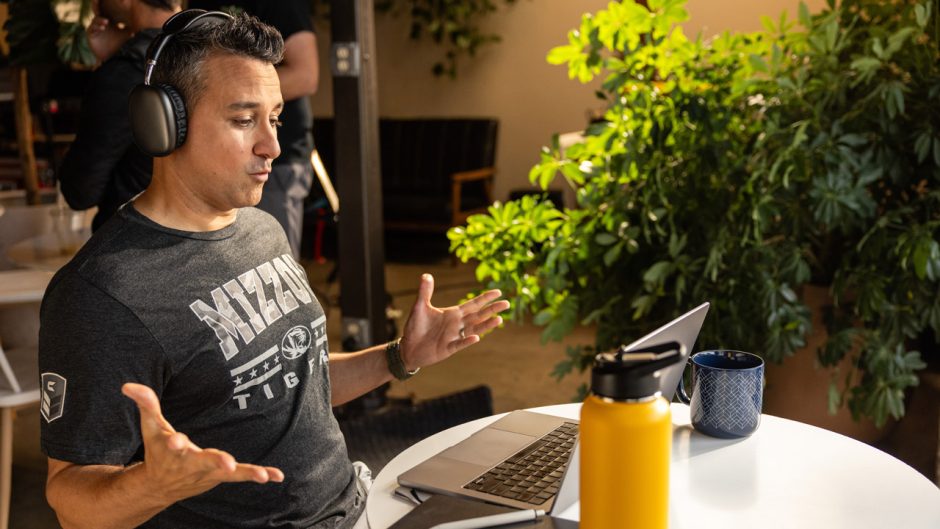 Student wearing headphones sitting at working on a laptop