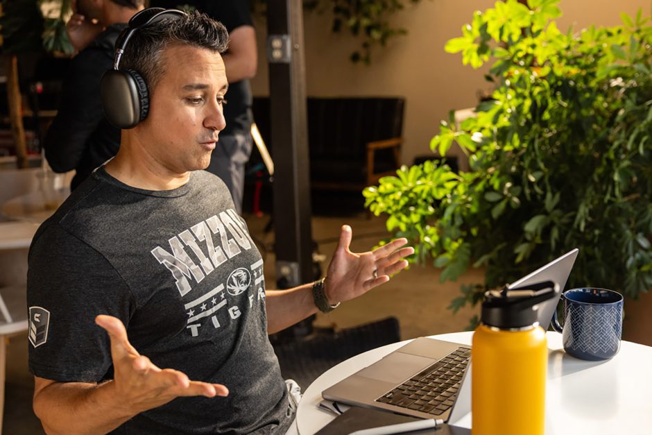 Student wearing headphones sitting at working on a laptop