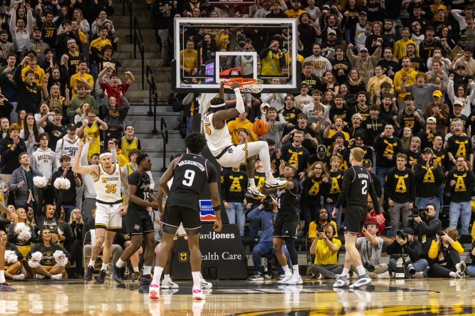 Mizzou basketball player hanging on rim after slam dunk