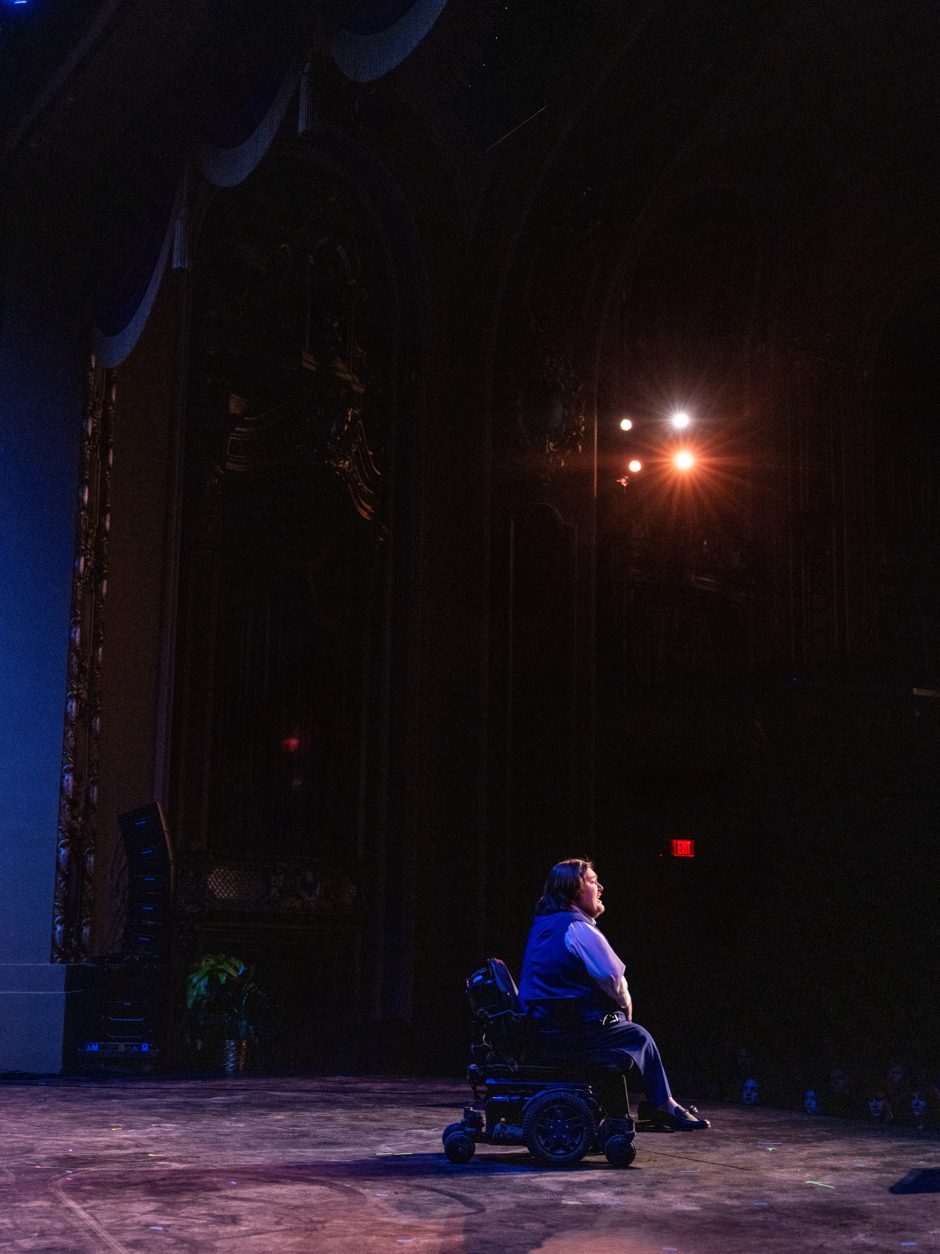Person seated in a wheelchair on a stage