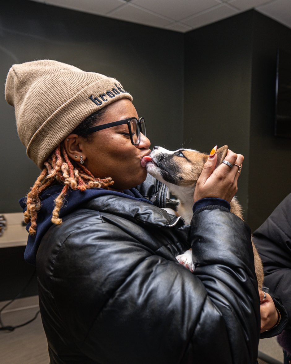 Student holding and kissing a puppy