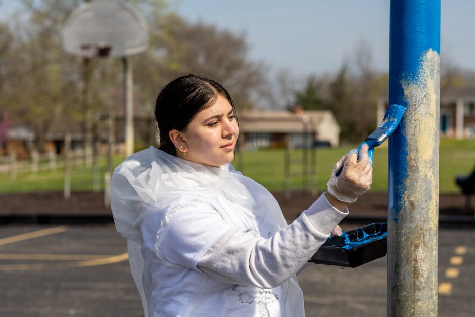Student painting a pole