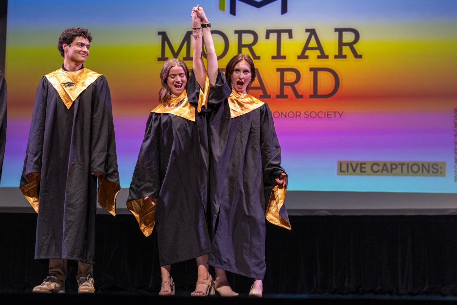 Student holding another student's arm up in celebration