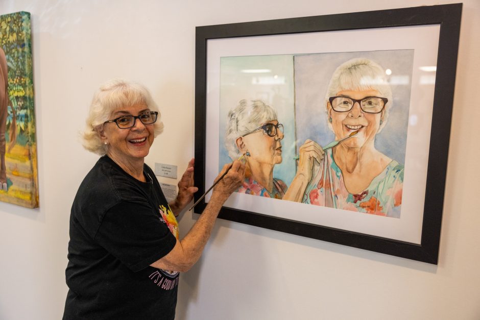 Artist pointing to a self portrait