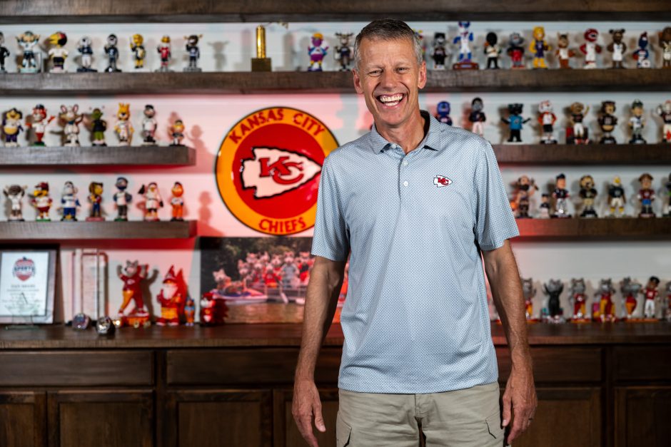 Person laughing in front of a Kansas City Chiefs sign