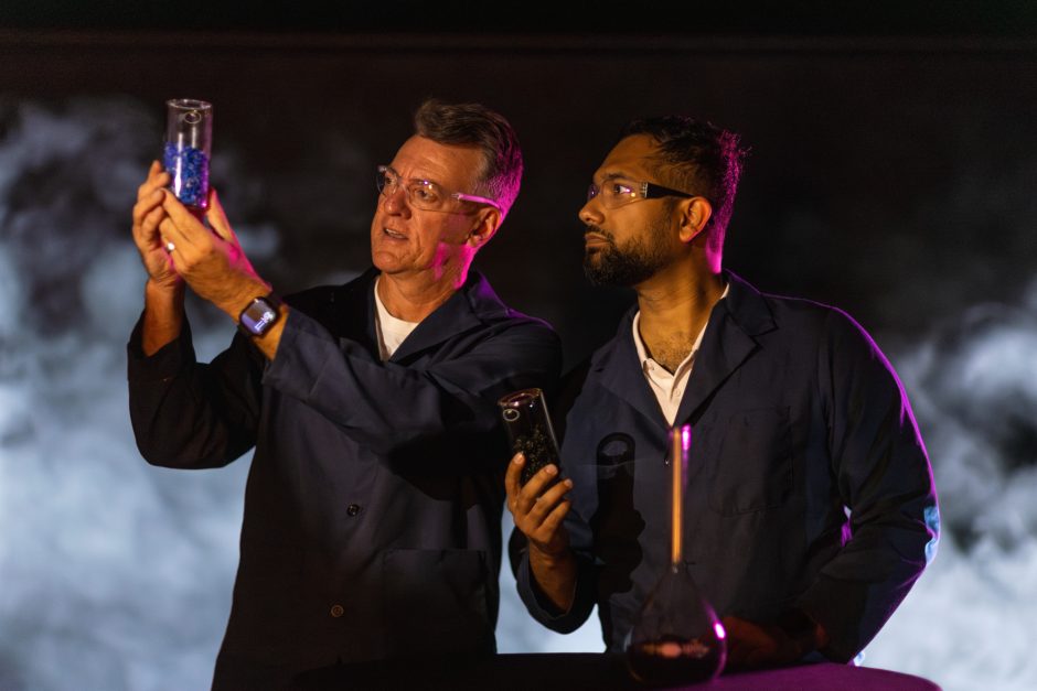 Two researchers look at beaker of material