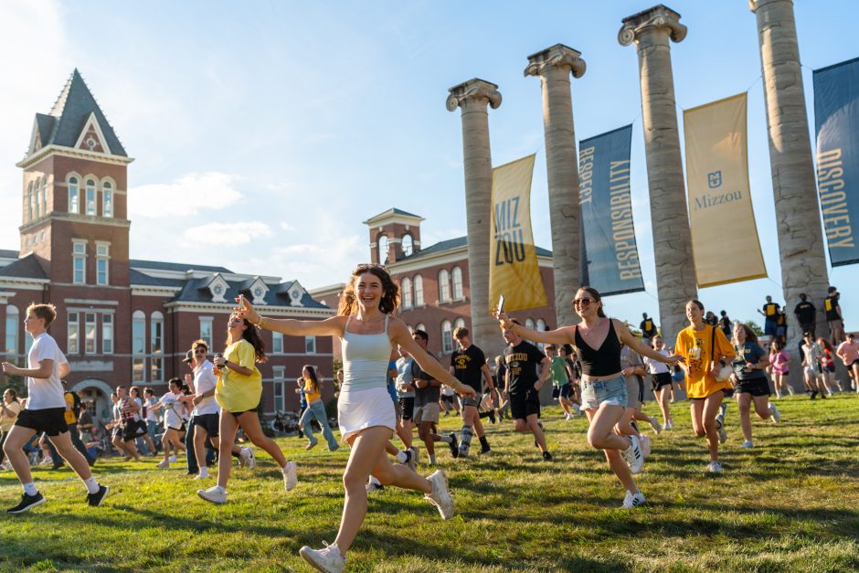Students running through the Columns