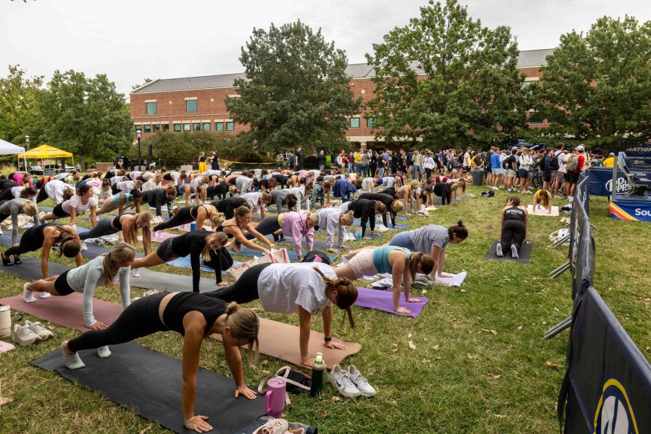 Group of people doing pilates routine outside
