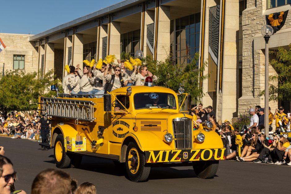 Yellow firetruck with Marching Mizzou members in the back