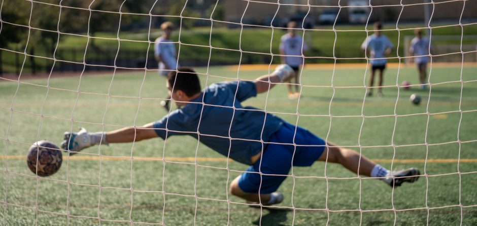 Soccer goalie diving for a ball
