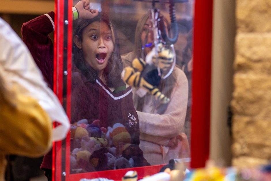 Student watching a claw-machine game