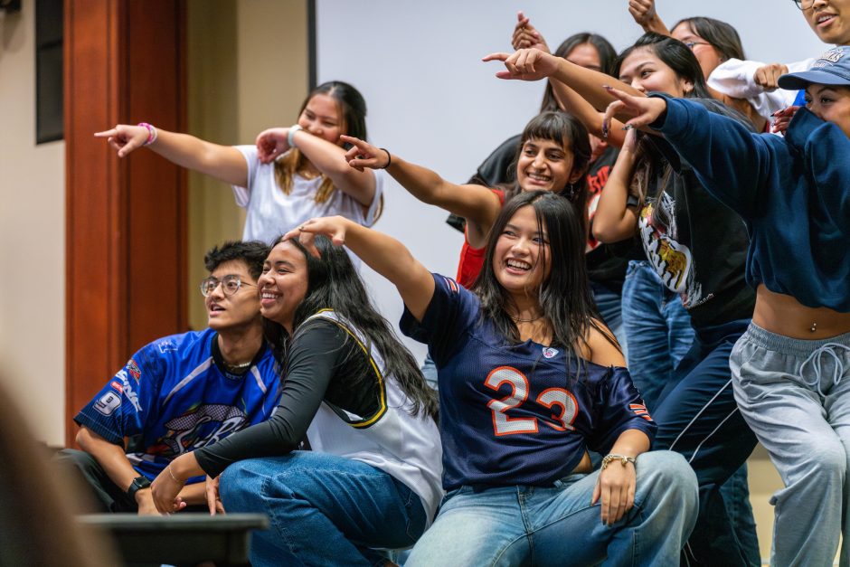 Group of students with arms extended