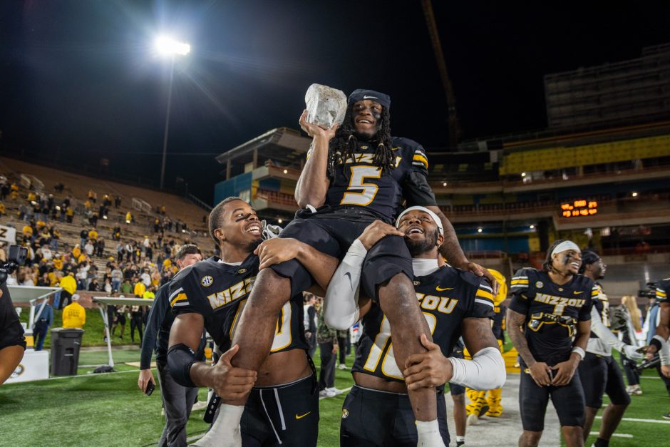 Football player on the shoulders of two teammates