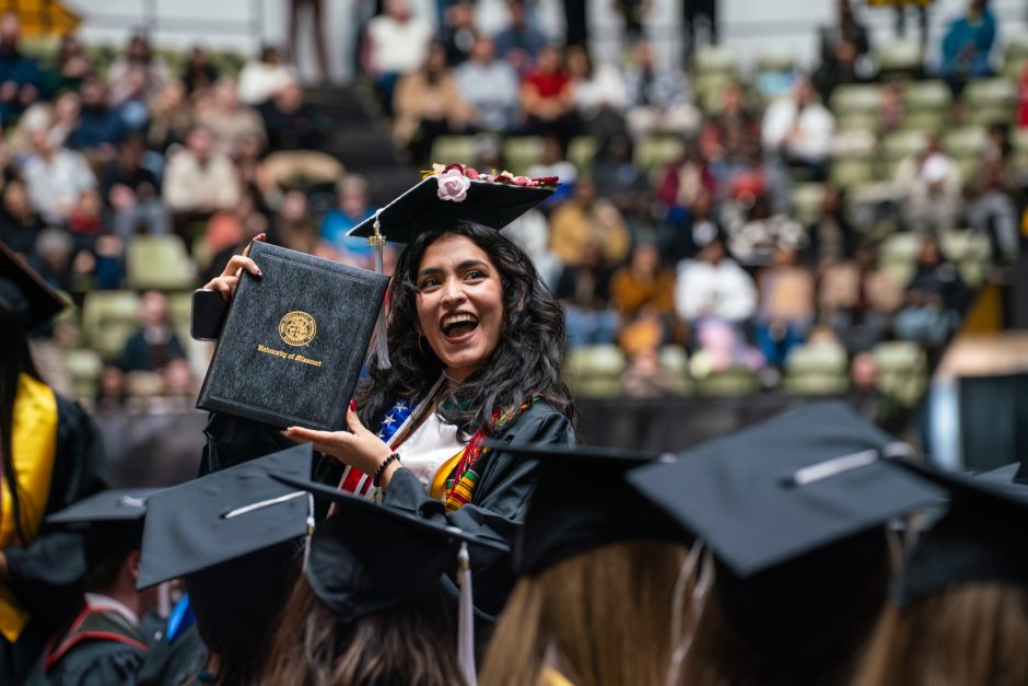 Graduate holding up diploma