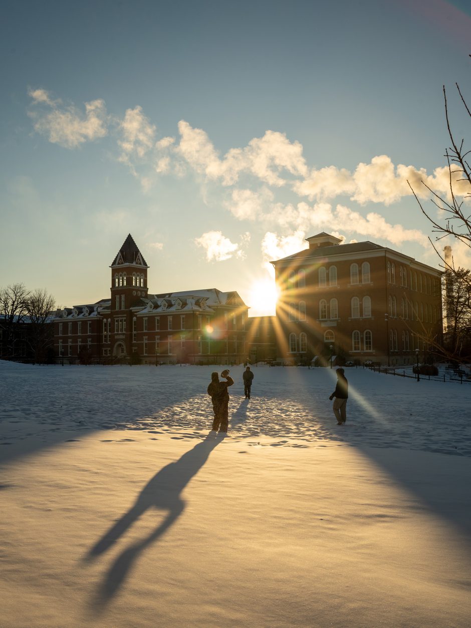 Students throwing football in the snow