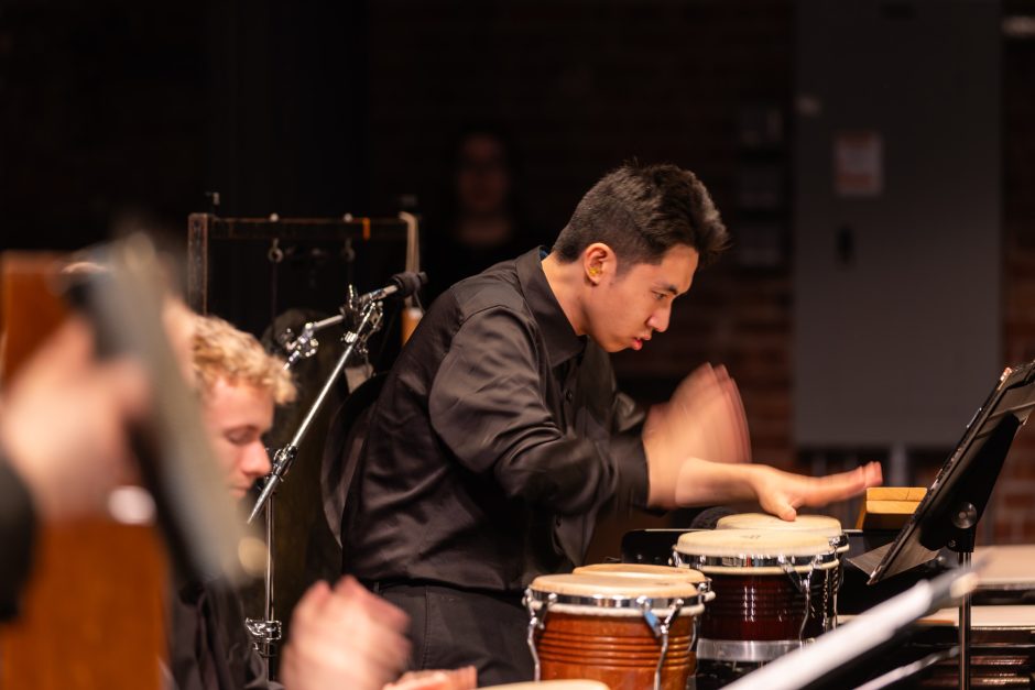 Student playing drums with hands
