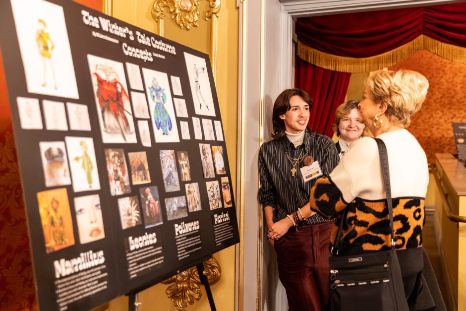 Student presenting art to an attendee