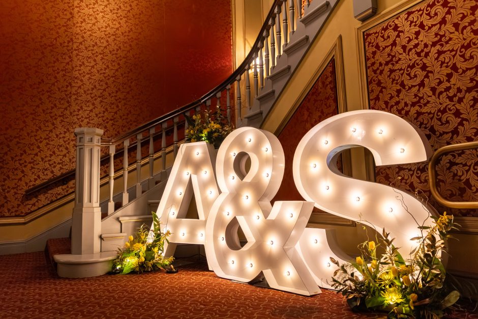 Large letters A and S in front of a staircase