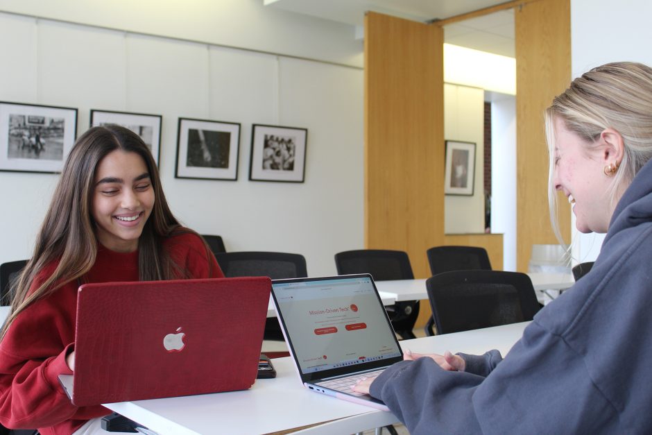 Two students work on laptops
