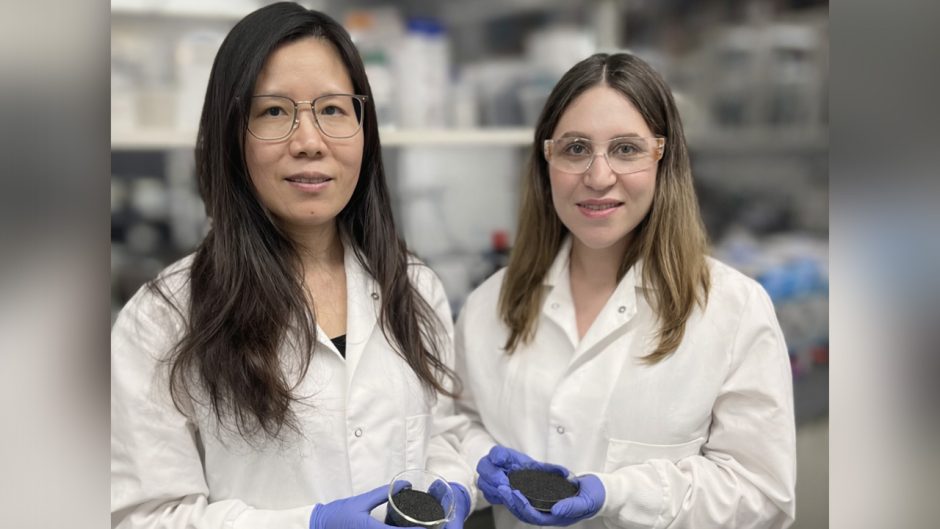 Two women in lab hold biochar