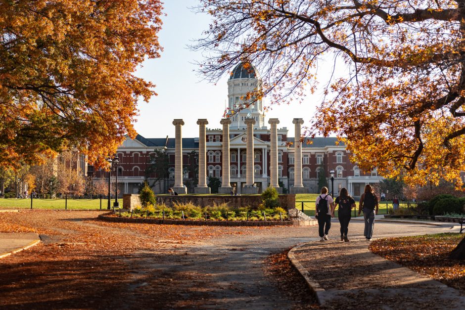 Students walk toward the Columns